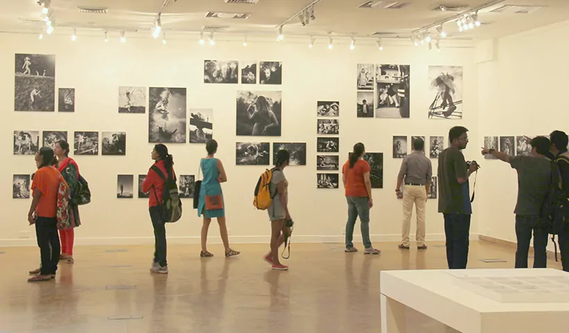 A group of people viewing an art exhibition. 